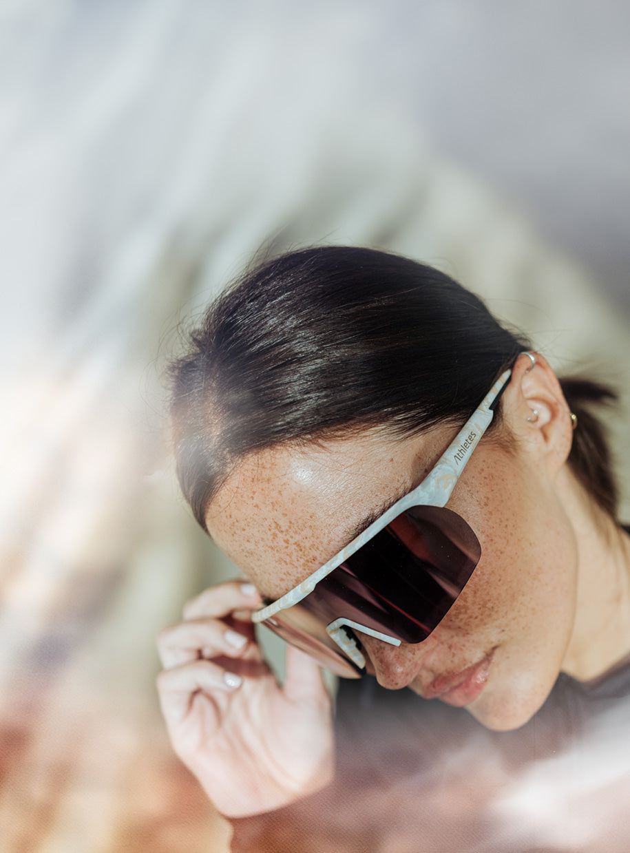 Woman with sporty sunglasses with dark lenses and light frame, close-up