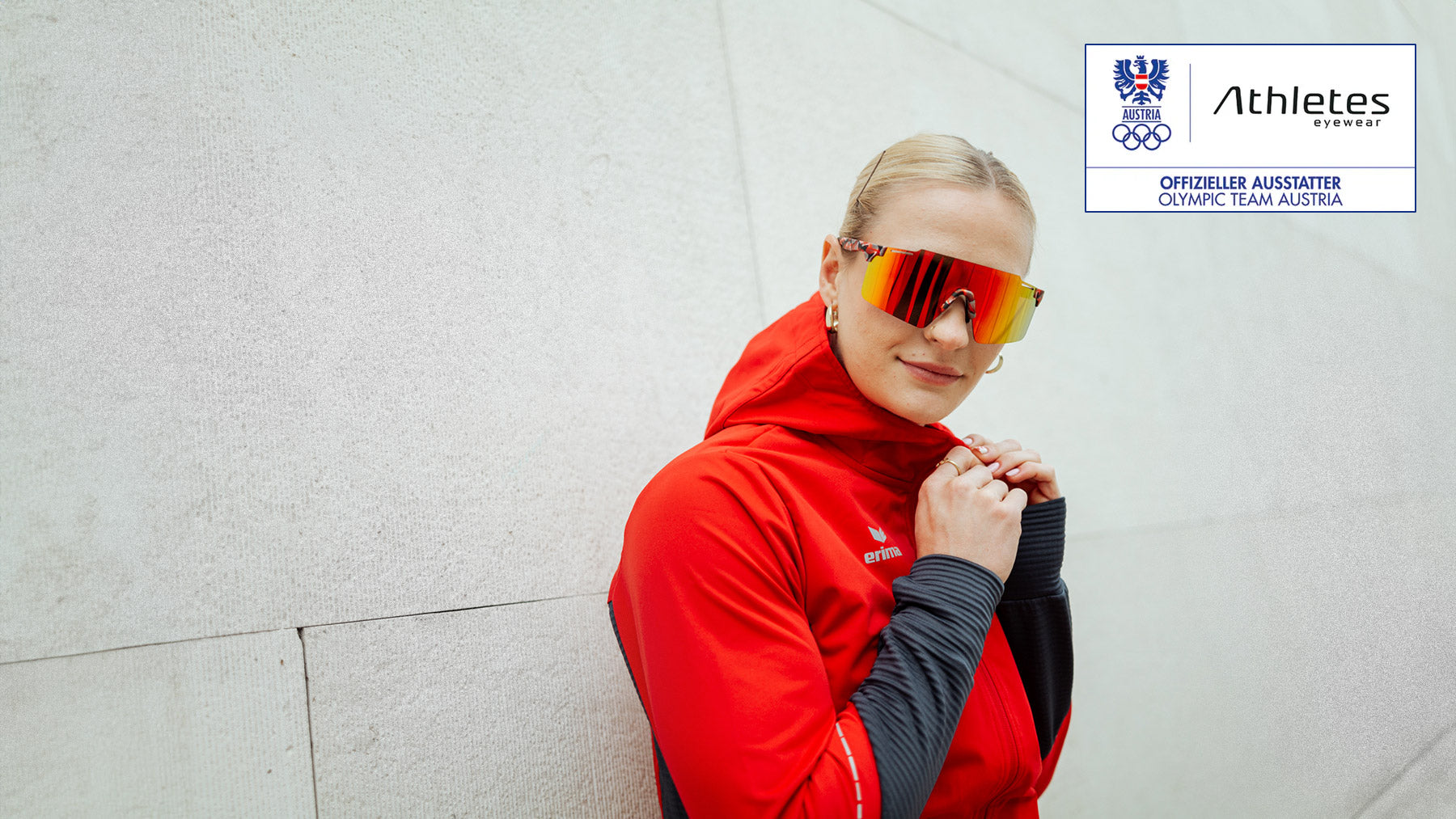 Woman of the Austrian Olympic team wears red sports jacket and sporty sunglasses