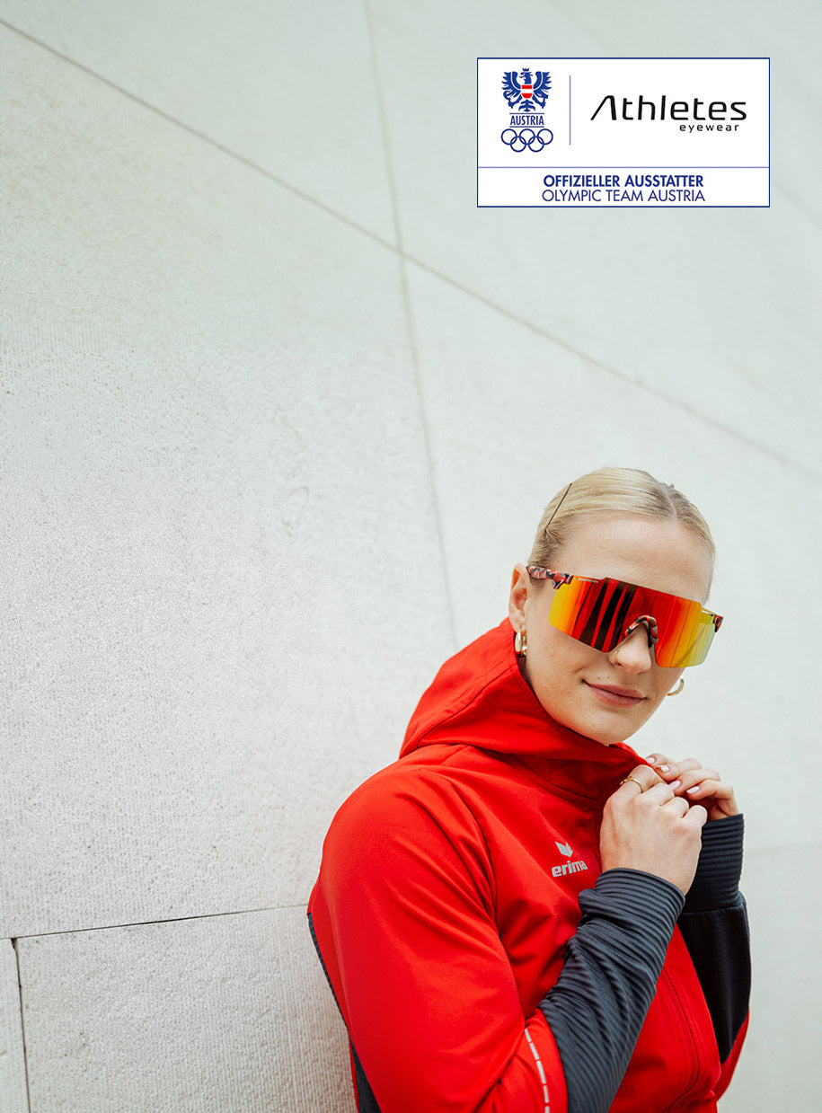 Woman of the Austrian Olympic team wears red sports jacket and sporty sunglasses